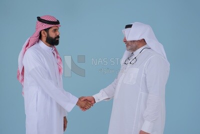 رجلين أعمال سعوديين يتصافحان بالزي السعودي التقليدي مشيرين بإشارة المصافحة ، الترحيب ، الاتفاق ، السلام ، التعارف ، مفهوم المواعدة