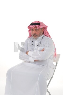 رجل سعودي مسن يجلس على كرسي ، آلام الظهر والعمود الفقري ، إرهاق وإرهاق ، تشنجات عضلية ، مشاكل صحية ، خلفية بيضاء ، موديل سعودي.