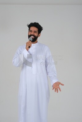 Saudi man in traditional dress holding the microphone, performing theatrical performances, giving speeches, dialogues and discussions, representative performance, lyrical theatrical art, white backgro