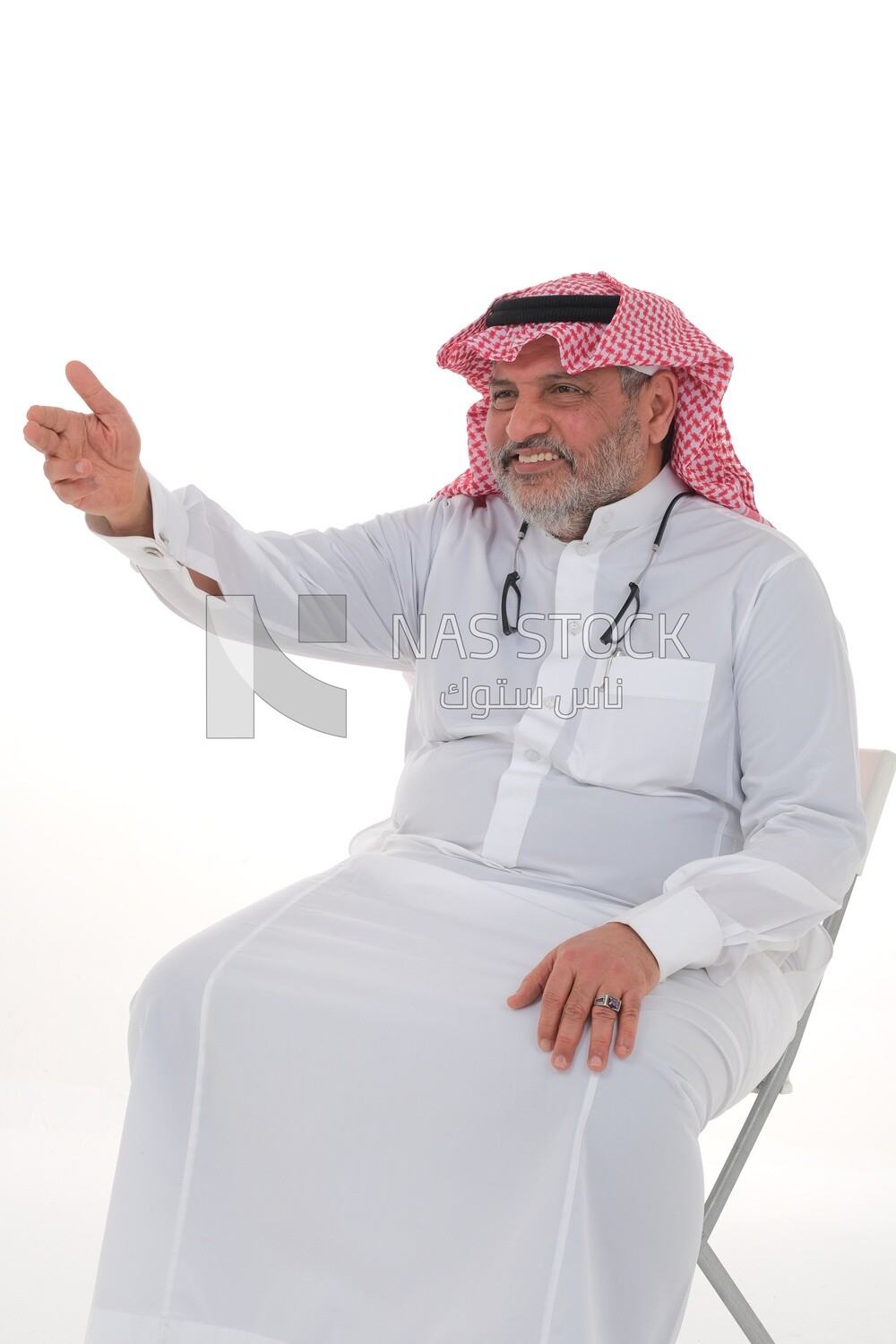 Saudi man wearing the Saudi thobe sitting on a chair, hand gestures pointing to the right, movements indicating this place, Saudi model, white background