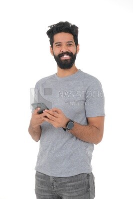 Saudi man wearing a casual drees, using a mobile phone, communicating with individuals, online requests and marketing, social relations, using technical devices, white background