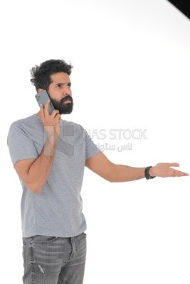 Saudi man wearing a casual drees, using a mobile phone, communicating with individuals, online requests and marketing, social relations, using technical devices, white background