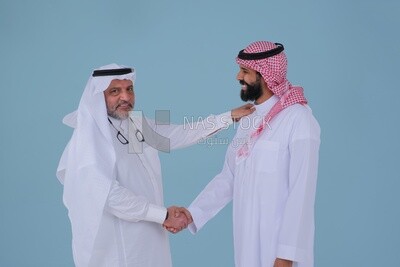 Two Saudi  businessmen shaking hands in traditional Saudi dress gesturing with handshake gesture, welcome, agreement, peace, acquaintance, dating concept