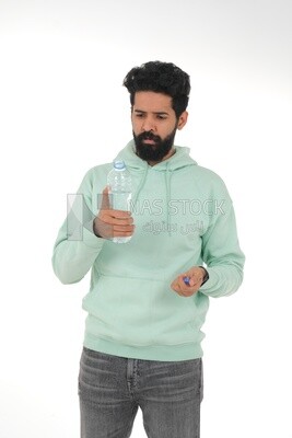 Saudi man wearing casual clothes, drinking from a water bottle, Saudi model, white background
