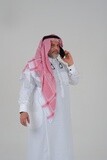 رجل سعودي يستخدم هاتف محمول ، يتواصل مع الأفراد ، طلبات وتسويق عبر الإنترنت ، علاقات اجتماعية ، باستخدام أجهزة تقنية ، خلفية بيضاء