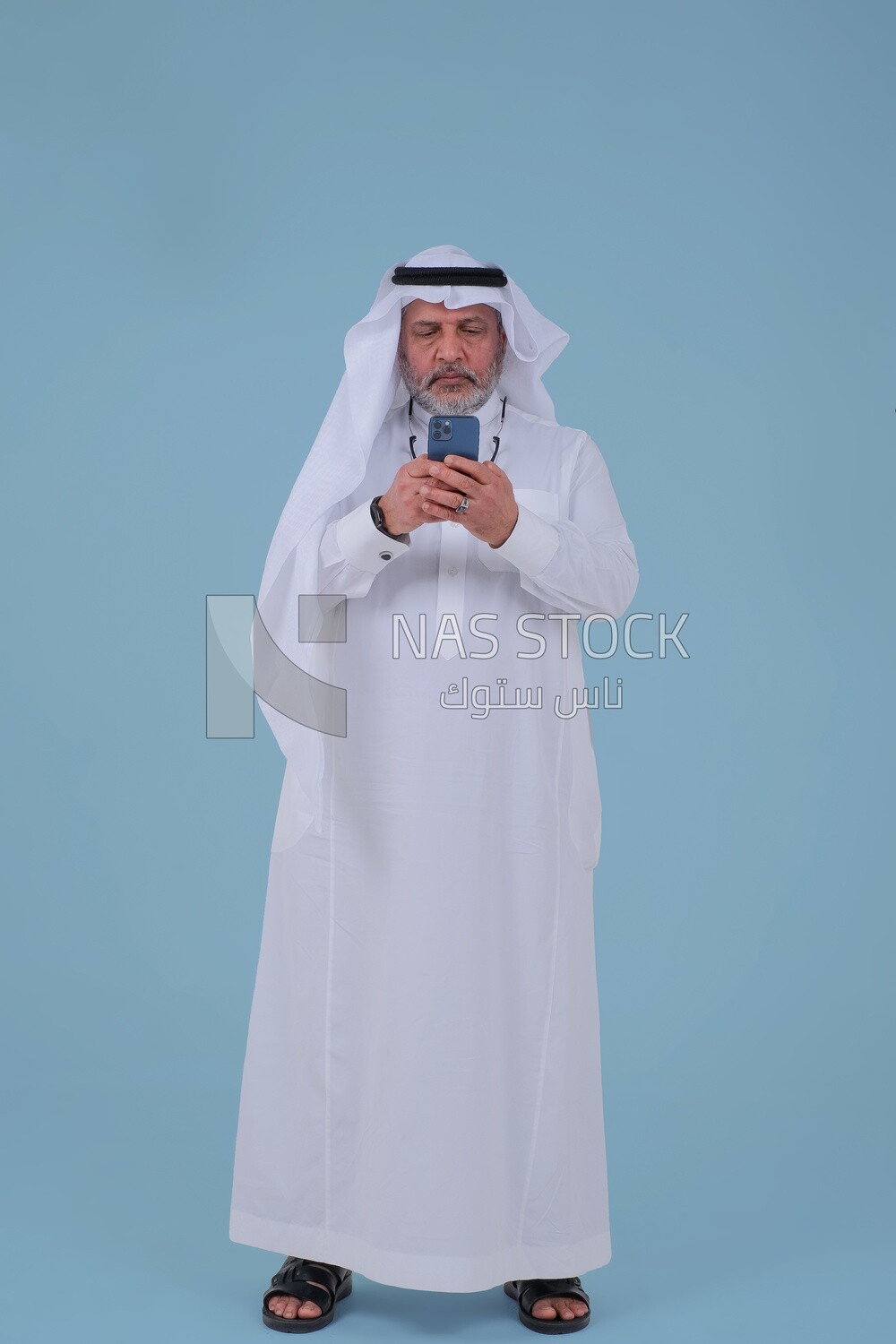 Saudi man using a mobile phone, communicating with individuals, online requests and marketing, social relations, using technical devices