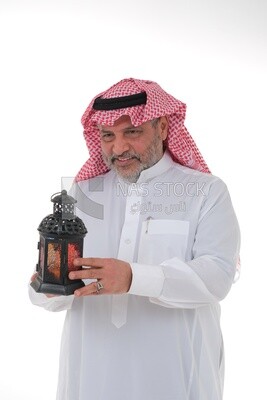 Saudi man holding a Ramadan lantern, Ramadan lantern, the blessed month of Ramadan, lighting and decorations for the month of Ramadan, Ramadan atmosphere, religious occasions