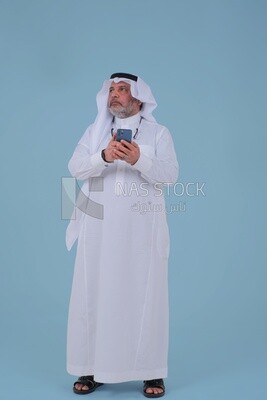 Saudi man using a mobile phone, communicating with individuals, online requests and marketing, social relations, using technical devices