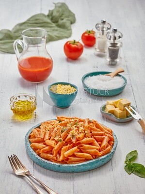 Dining table with a plate of pasta in red sauce