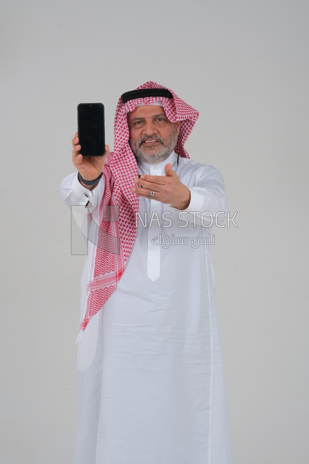 Saudi man using a mobile phone pointing on it, communicating with individuals, online requests and marketing, social relations, using technical devices, white background