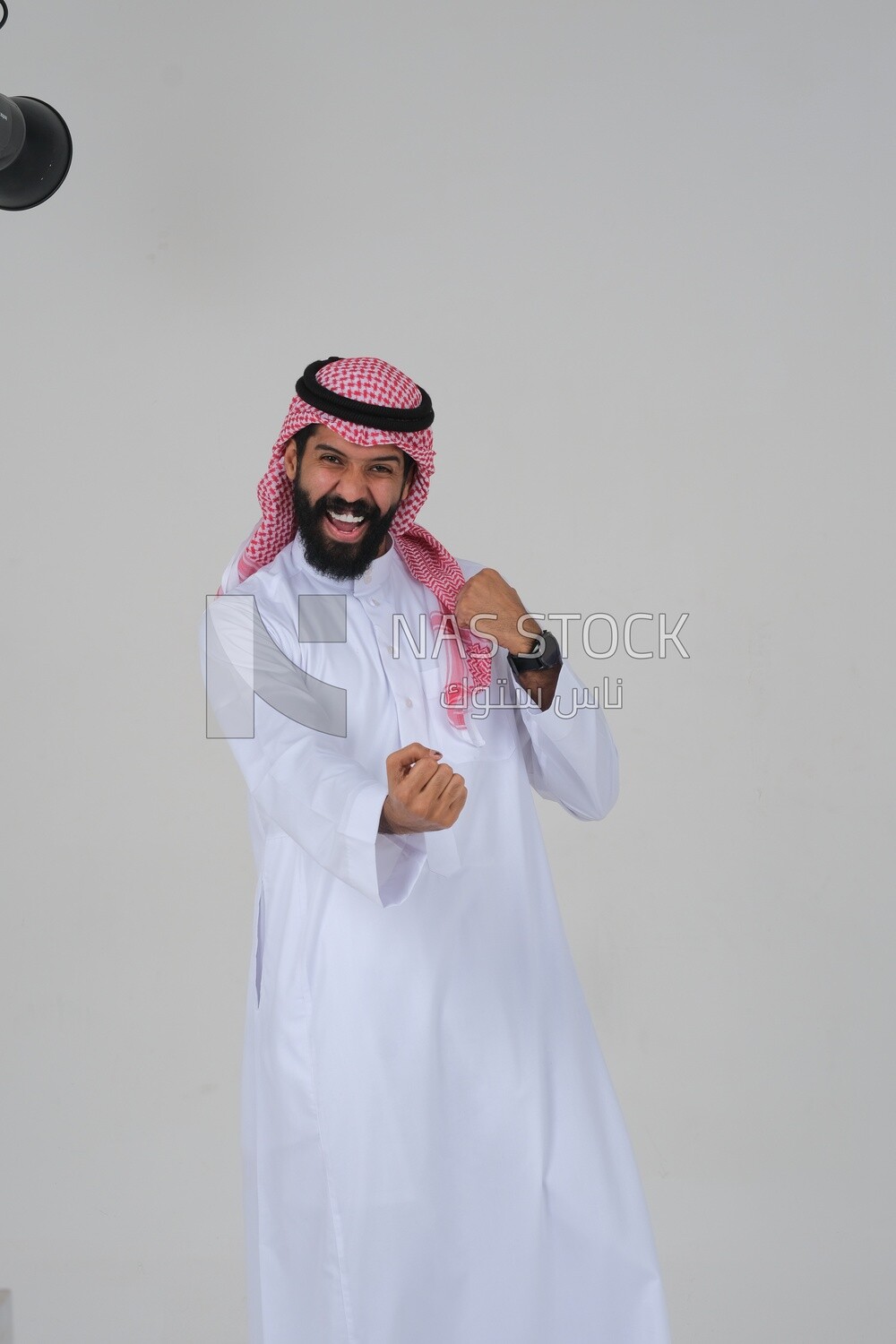 رجل سعودي يرتدي ثوبا أبيض يبدو سعيدا ، إيماءات على الوجه تدل على السعادة والفرح ، والثقة بالنفس ، وخلفية بيضاء ، موديل سعودى