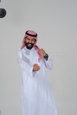 Saudi man wearing a white dress looks happy, facial gestures indicating happiness and joy, self-confidence, white background, Saudi model