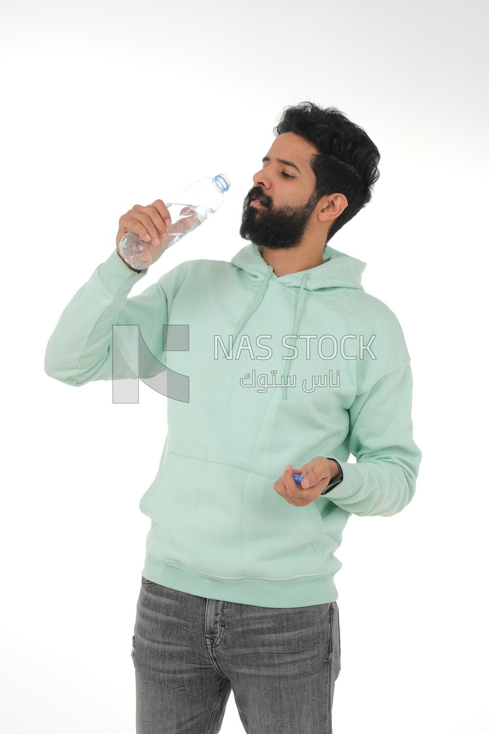 Saudi man wearing casual clothes, drinking from a water bottle, Saudi model, white background