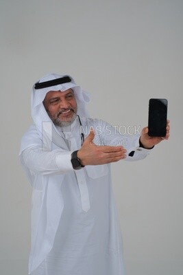 Saudi man using a mobile phone pointing on it, communicating with individuals, online requests and marketing, social relations, using technical devices, white background