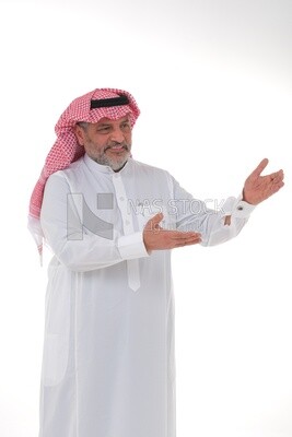 Saudi man wearing the Saudi thobe sitting on a chair, hand gestures pointing to the right, movements indicating this place, Saudi model, white background