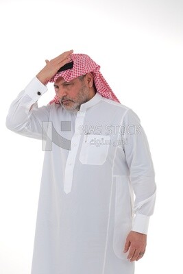 elderly Saudi man with his hands on his head, feeling pain and headache, wearing a white dress with a shemagh and headband, white background, an elderly man with pain in his head, the concept of bo