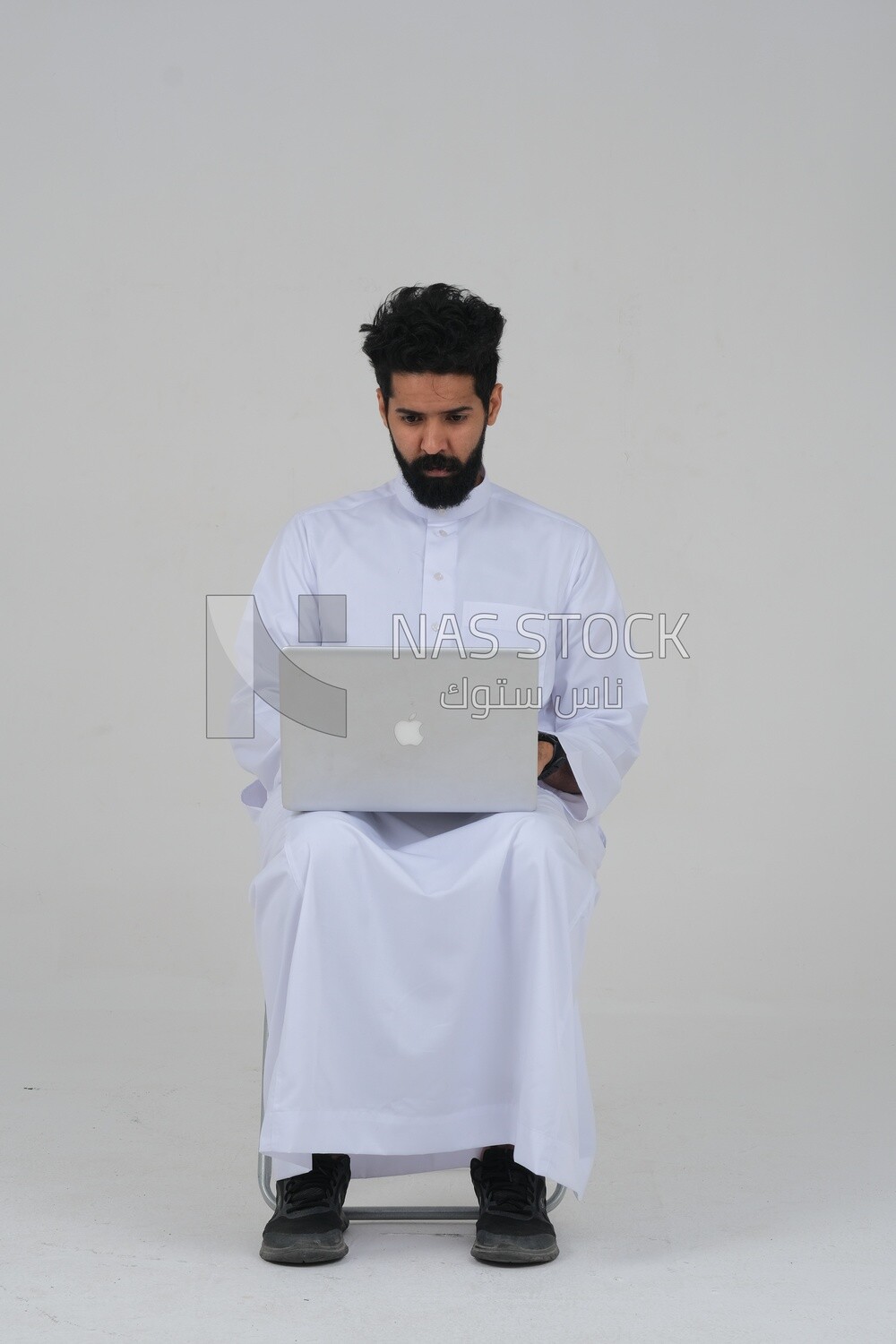 Saudi man sitting in front of a laptop, business feasibility study, white background, Saudi model