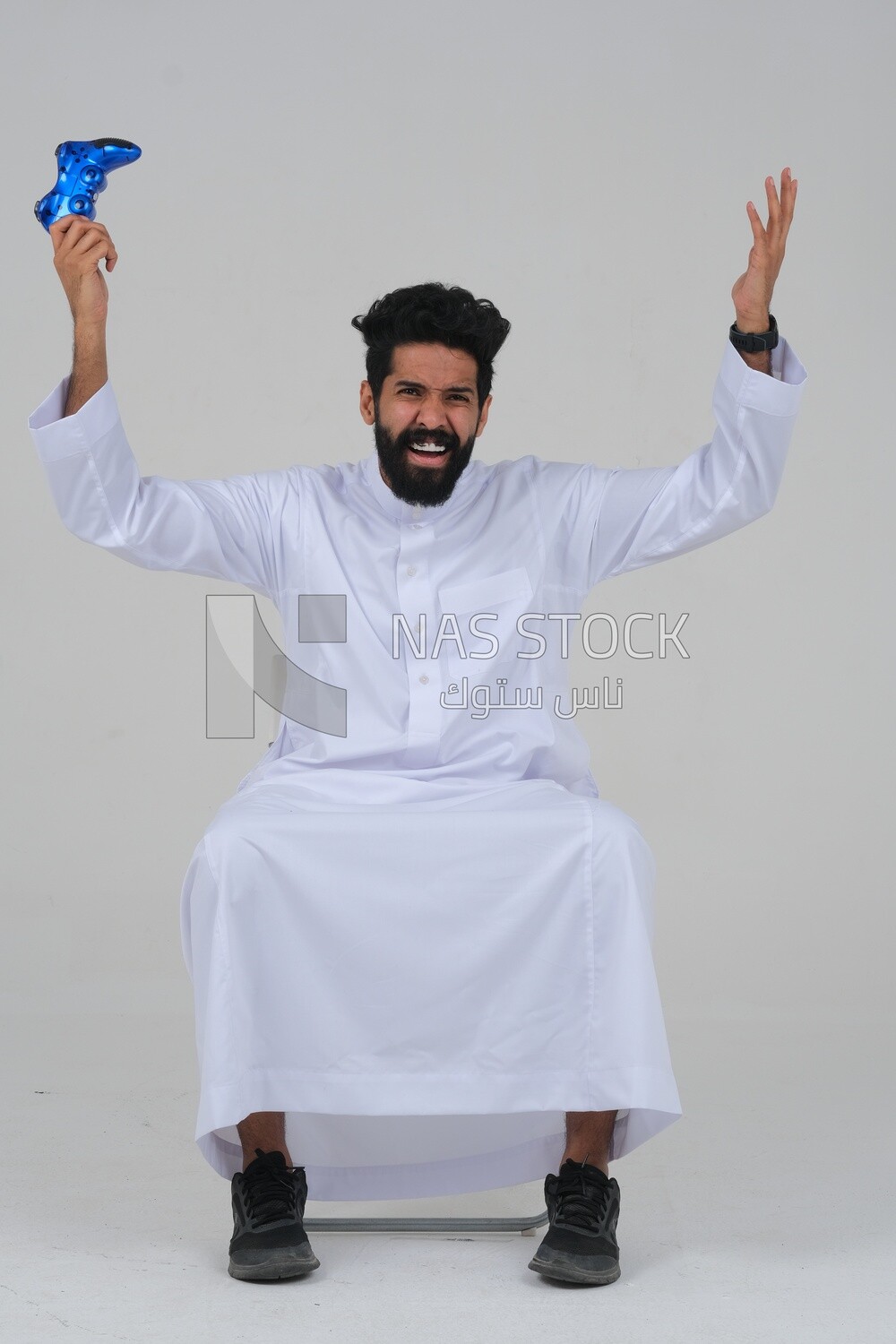 saudi  man holding a joystick in his hand and playing video games, with gestures and expressions that indicate focus and harmony, fun and entertainment with video games