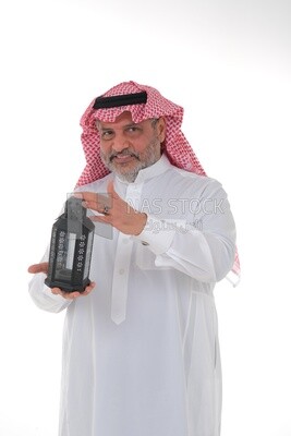 Saudi man holding a Ramadan lantern, Ramadan lantern, the blessed month of Ramadan, lighting and decorations for the month of Ramadan, Ramadan atmosphere, religious occasions