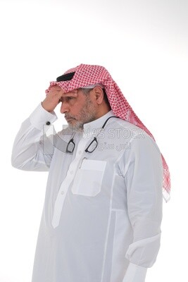 elderly Saudi man with his hands on his head, feeling pain and headache, wearing a white dress with a shemagh and headband, white background, an elderly man with pain in his head, the concept of bo