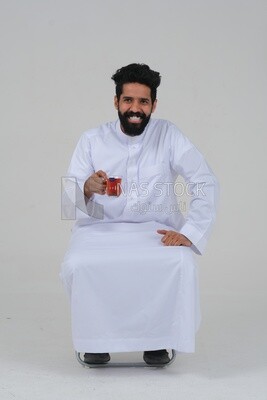 Saudi man wearing a white dress, drinking a cup of tea, self-confidence, white background, Saudi model