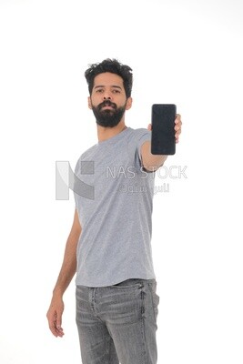 close-up of a Saudi man, wearing casual clothes, carrying his mobile phone, Saudi model, white background