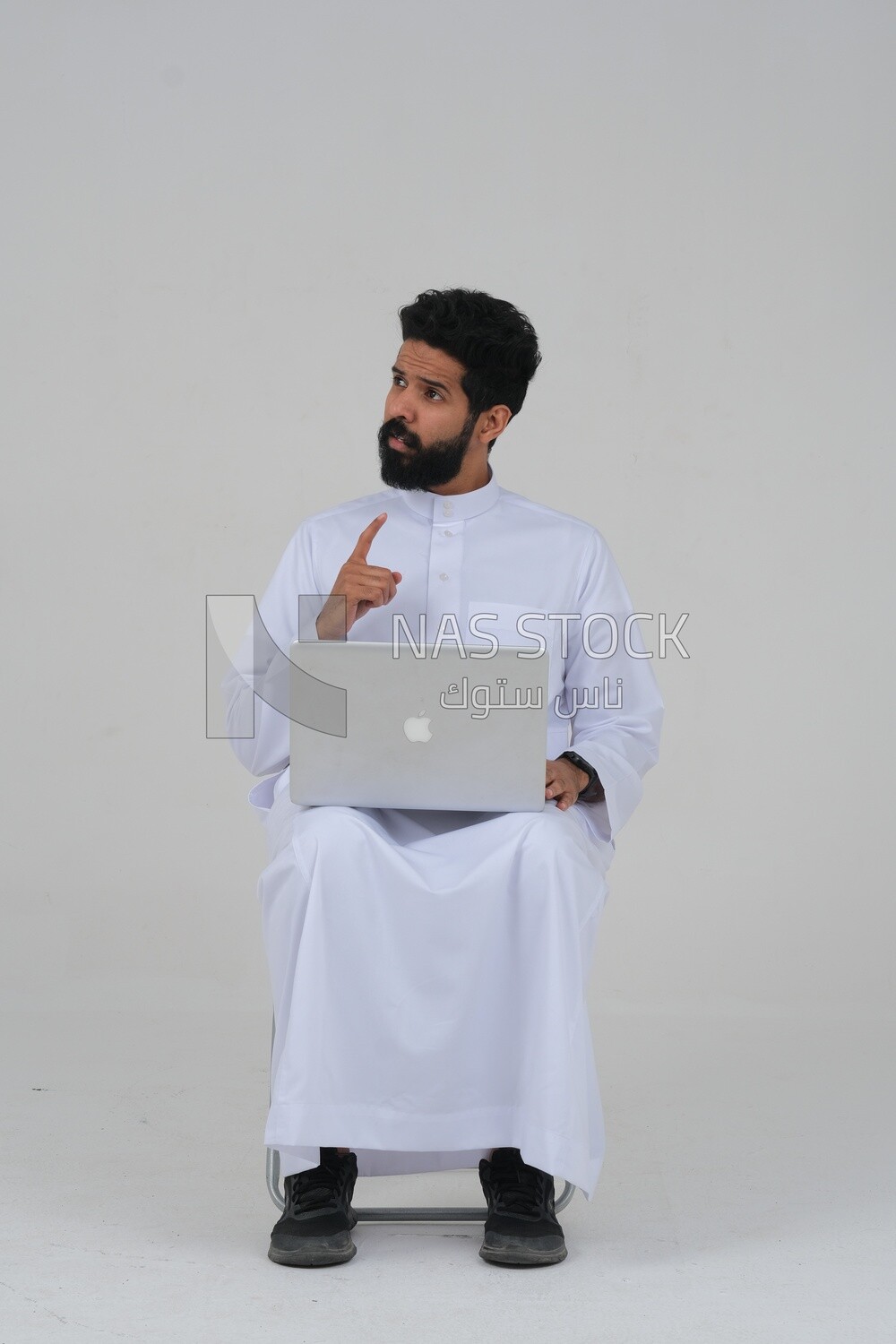 Saudi man sitting in front of a laptop, business feasibility study, white background, Saudi model