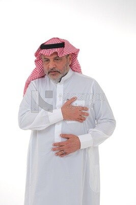 saudi man putting his hand on his chest and feeling a state of tingling and pain in his heart, close-up, a young Saudi man wearing a white dress with a shemagh and headband, white background