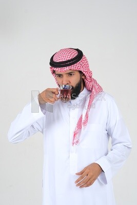 Saudi man wearing a white dress, drinking a cup of tea, self-confidence, white background, Saudi model