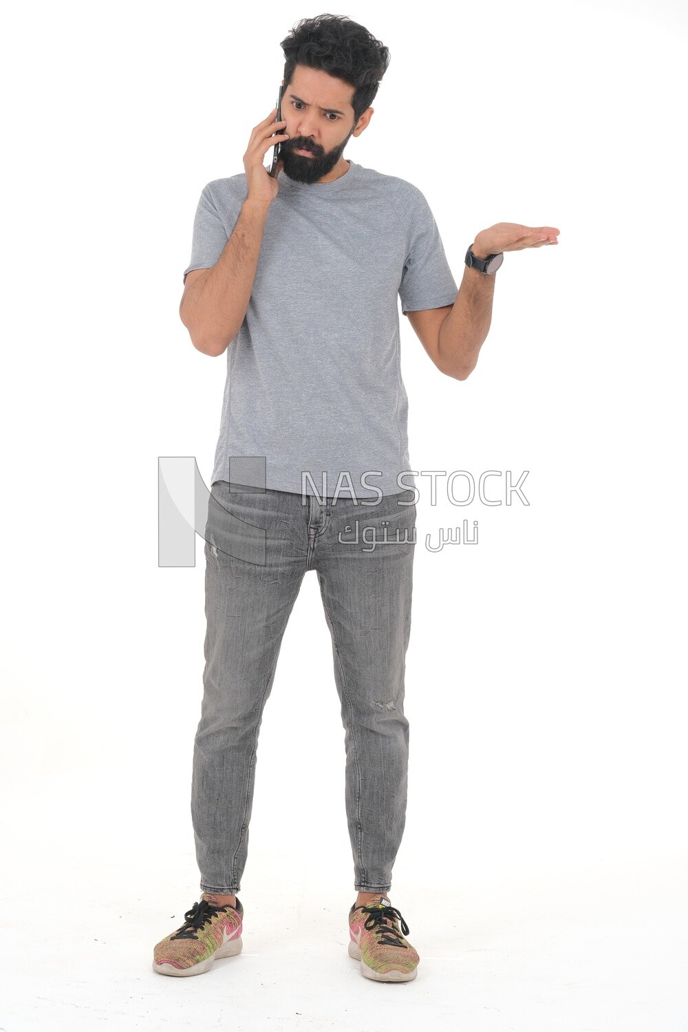 close-up of a Saudi man looking angry, wearing casual clothes, carrying his mobile phone, Saudi model, white background