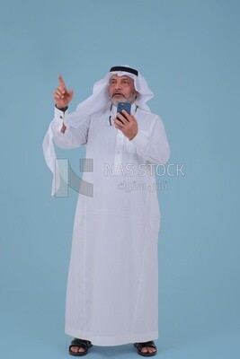 Saudi man using a mobile phone pointing away, communicating with individuals, online requests and marketing, social relations, using technical devices
