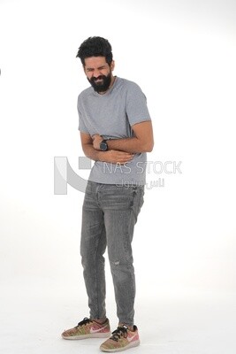 Saudi man placing his hands on his stomach,  abdominal and stomach pain, intestinal disorders, digestive system imbalance, white background
