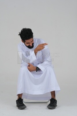 close-up of a Saudi man in traditional Saudi dress pointing away, side view, Saudi model, white background