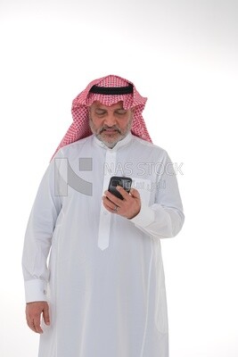 رجل سعودي مسن  يستخدم هاتف محمول ، يتواصل مع الأفراد ، طلبات وتسويق عبر الإنترنت ، علاقات اجتماعية ، باستخدام أجهزة تقنية ، خلفية بيضاء