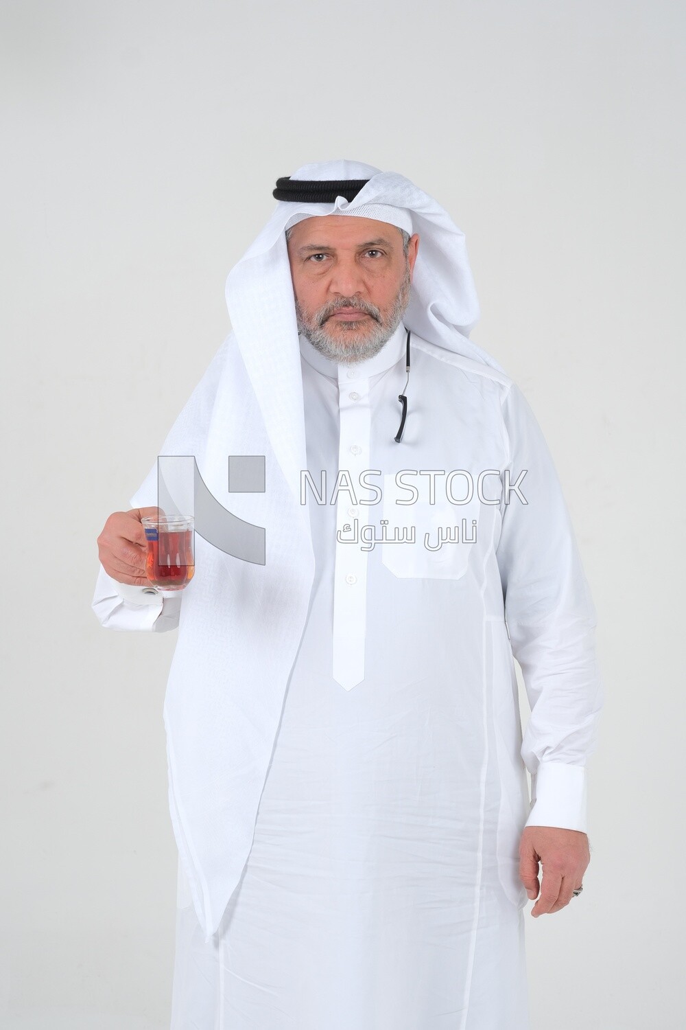 Saudi man wearing a white dress, drinking a cup of tea, self-confidence, white background, Saudi model
