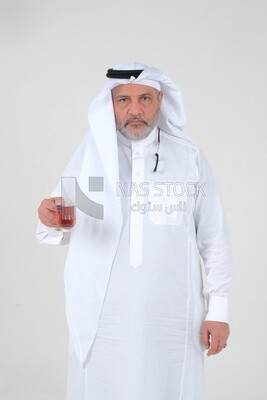 Saudi man wearing a white dress, drinking a cup of tea, self-confidence, white background, Saudi model