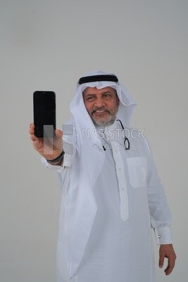 elderly Saudi man using a mobile phone, communicating with individuals, online requests and marketing, social relations, using technical devices, white background