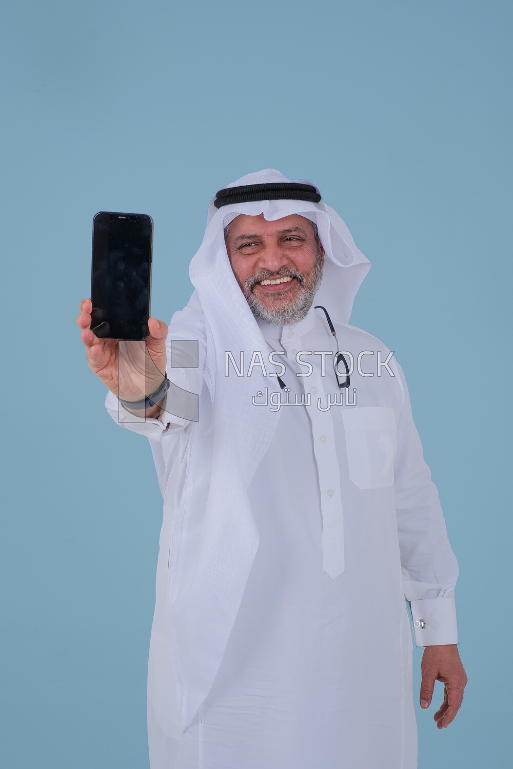 Saudi man using a mobile phone, communicating with individuals, online requests and marketing, social relations, using technical devices
