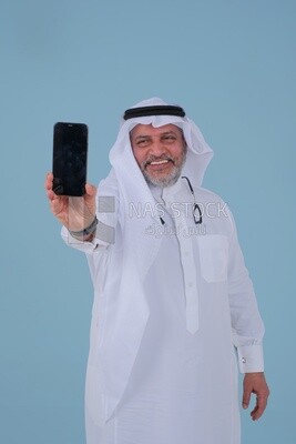 Saudi man using a mobile phone, communicating with individuals, online requests and marketing, social relations, using technical devices