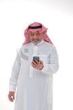 رجل سعودي مسن  يستخدم هاتف محمول ، يتواصل مع الأفراد ، طلبات وتسويق عبر الإنترنت ، علاقات اجتماعية ، باستخدام أجهزة تقنية ، خلفية بيضاء