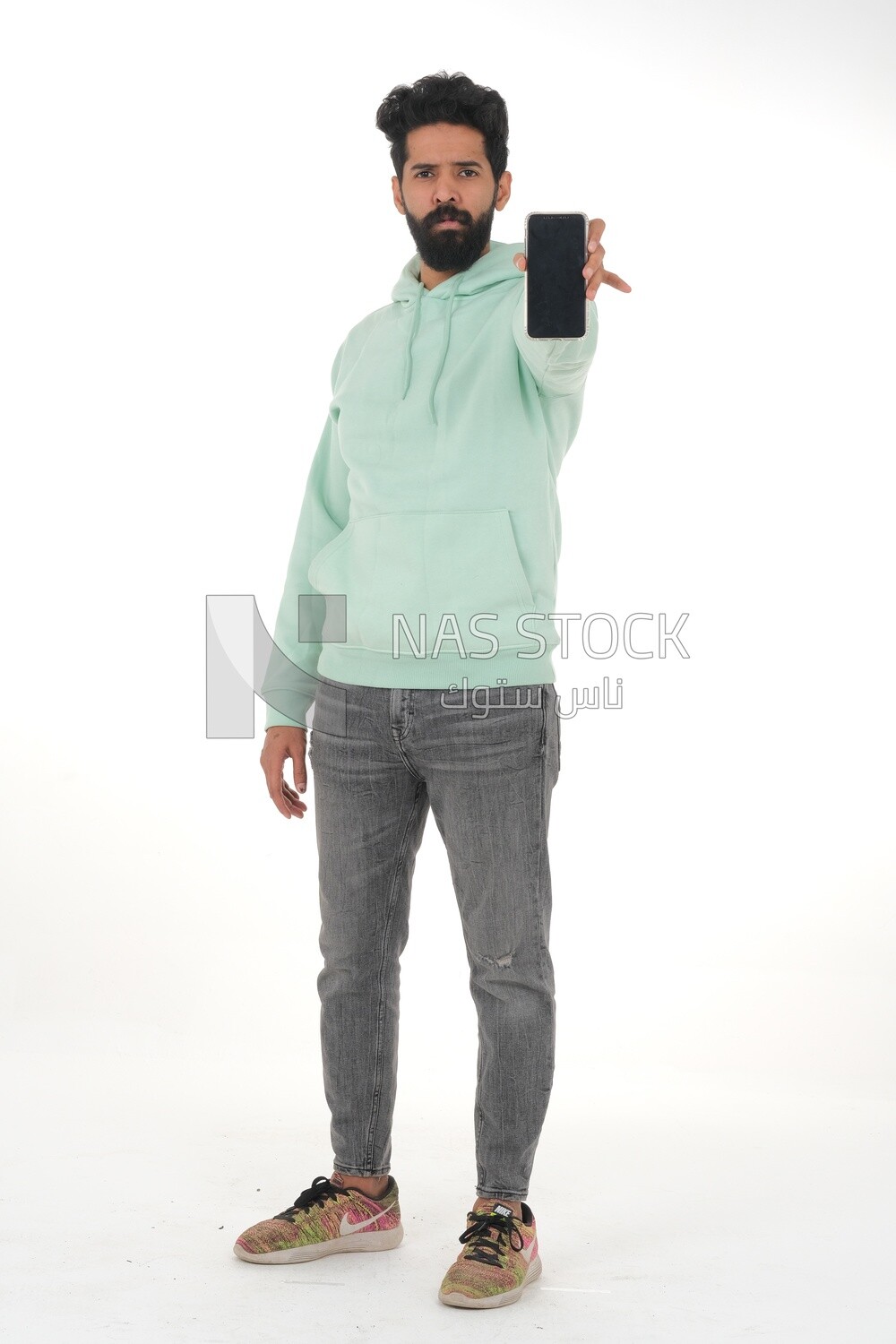 close-up of a Saudi man, wearing casual clothes, carrying his mobile phone, Saudi model, white background