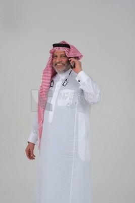 elderly Saudi man using a mobile phone, communicating with individuals, online requests and marketing, social relations, using technical devices, white background