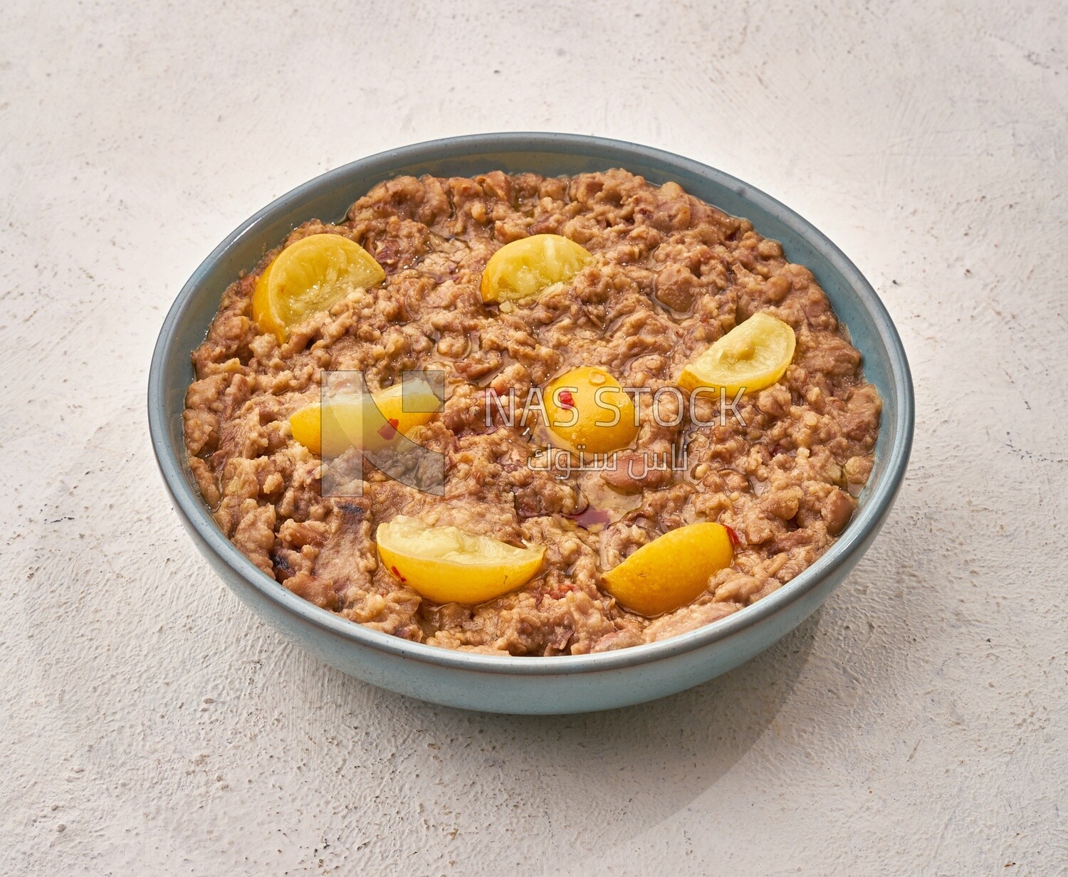 Close-up of oriental breakfast, a dish of foul medames with lemon slices, Arabic breakfast, arab restaurant