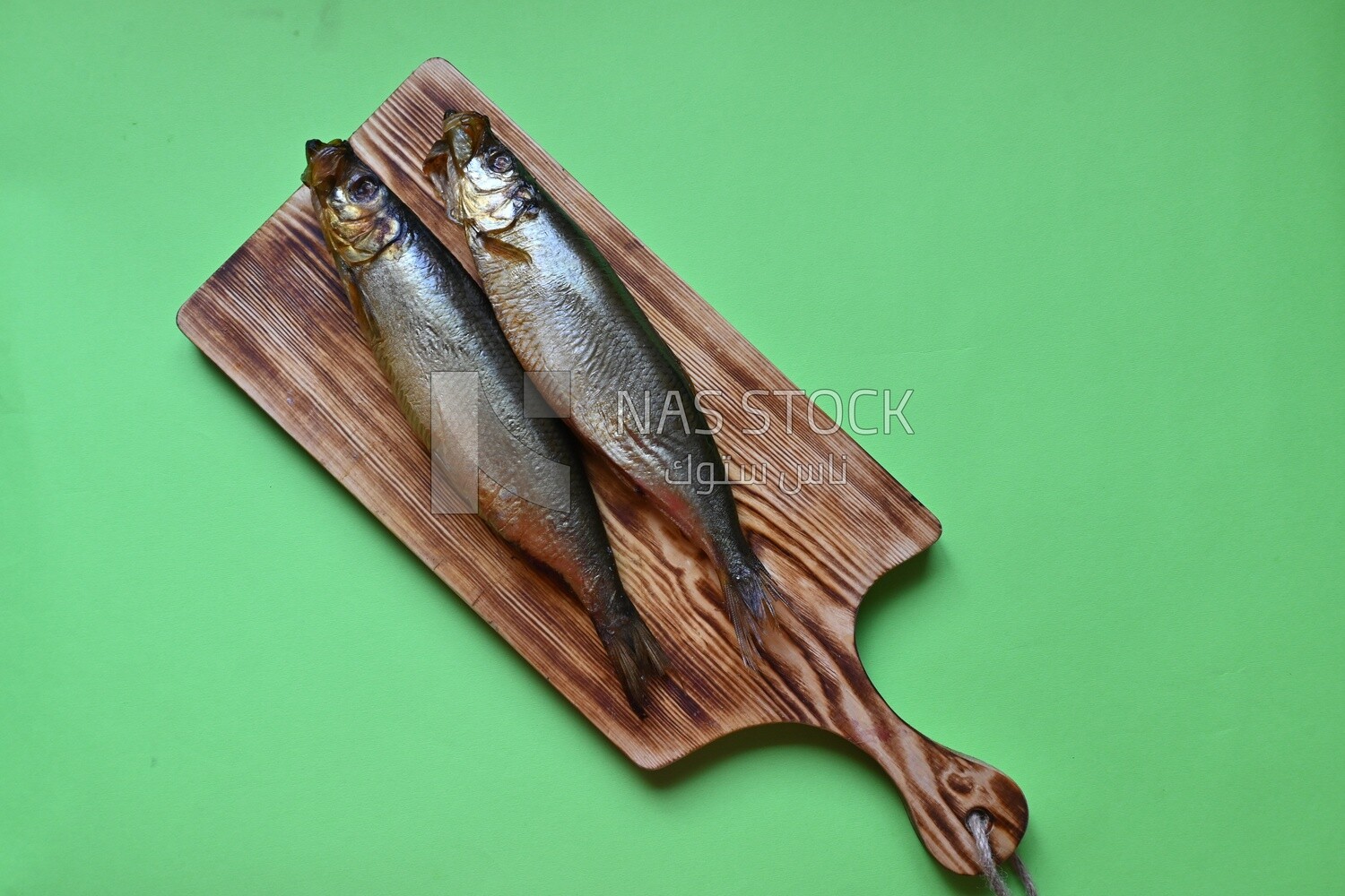 Smoked herring on a Cutting and Serving Board, lemon and onion, traditional food, smoked fish