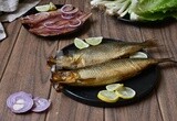 Smoked herring on a Cutting and Serving Board, herring fillet with lemon on a plate, lemon and onion, traditional food, smoked fish