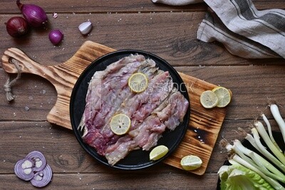 Herring fillet with lemon on a plate on a Cutting and Serving Board, traditional food, smoked fish