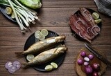 Smoked herring on a Cutting and Serving Board, lemon and onion, traditional food, smoked fish