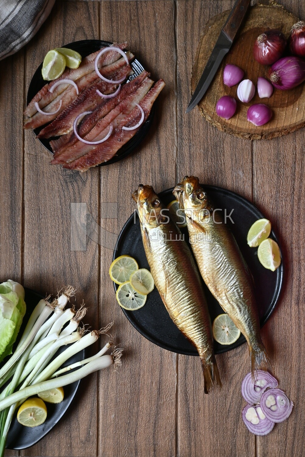 Smoked herring on a Cutting and Serving Board, herring fillet with lemon on a plate, lemon and onion, traditional food, smoked fish