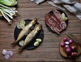 Smoked herring on a Cutting and Serving Board, herring fillet with lemon on a plate, lemon and onion, traditional food, smoked fish