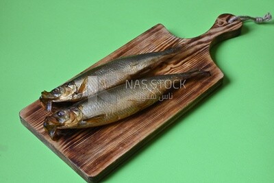 Smoked herring on a Cutting and Serving Board, traditional food, smoked fish